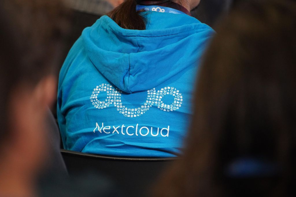 Picture showing the pack of person wearing a jumper with the Nextcloud logo as illustration to the blog post Nextcloud Community Conference 2025 guide
